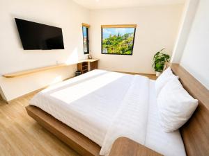 a bedroom with a white bed and a flat screen tv at The SunHill Dalat in Ấp Ða Lợi +33 photos