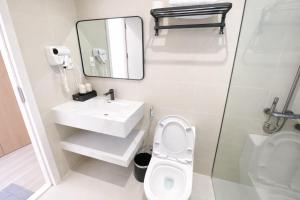a bathroom with a sink and a toilet and a mirror at The SunHill Dalat in Ấp Ða Lợi
