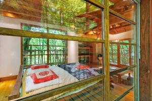 a bedroom with a bed in a room with windows at La Cabane Zen in Angoisse