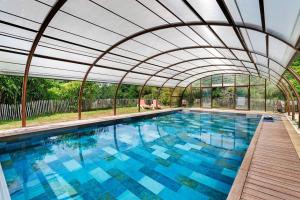 an indoor swimming pool with a retractable roof at La Cabane Zen in Angoisse