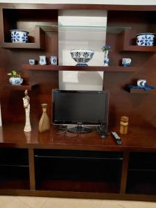 a television on a wooden desk with shelves at Sonho de Minas Hospedaria in Ouro Preto