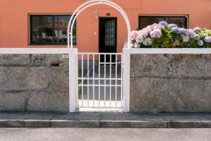 a white gate with flowers on it in front of a building at Casa Praia Norte - PVZ in Póvoa de Varzim