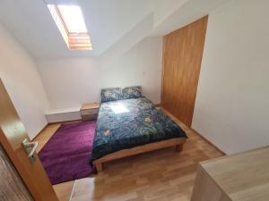 a bedroom with a bed with a purple rug at Vous êtes bienvenue in Ramstein-Miesenbach