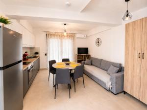 a living room with a couch and a table and chairs at Crystal 2 Apartment Ofrinio in Ofrínion