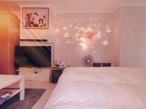 a bedroom with a white bed and lights on the wall at Niwill Homestay in Taichung