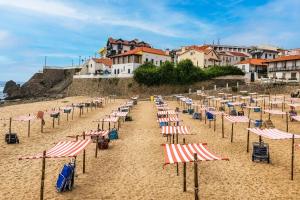 a bunch of chairs and umbrellas on a beach at Kampaoh São Pedro de Moel in Marinha Grande