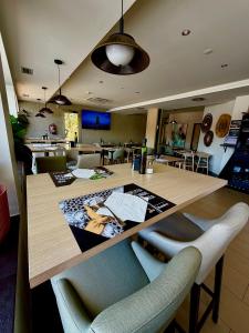 a kitchen with a large wooden table with chairs at Hotel El Cruce Moraleda in Moraleda de Zafayona