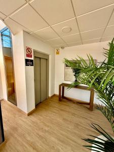 an empty room with a table and a plant at Hotel El Cruce Moraleda in Moraleda de Zafayona