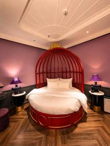 a red bed in a room with two lamps at Loom Hotel Hanoi in Hanoi +62 photos
