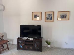 a living room with a flat screen tv on a white wall at Villa Vassia in Koundouros