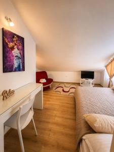 a bedroom with a desk and a bed in a room at Pensiunea CARLA in Sărata-Monteoru