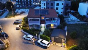 a house with cars parked in a parking lot at Apartments Vukalovic in Medulin