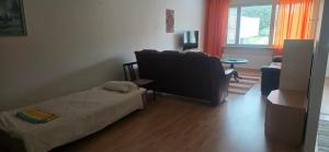 a bedroom with a bed and a couch and a window at Pankkikallio 16 in Sorsakoski