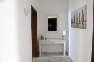 un pasillo con una mesa blanca y un espejo en Nonna grazia, en Roma