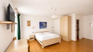 a bedroom with a bed and a table in it at Garni Il Muretto in Lavarone