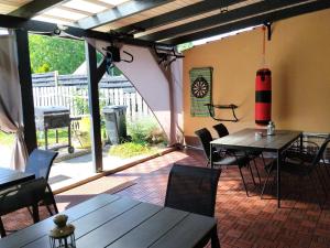 a patio with tables and chairs and a large window at Villa La Vita in Hévíz