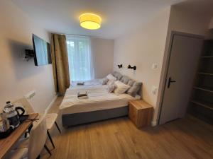 a bedroom with a bed and a desk and a window at PannaiLew in Ciechocinek