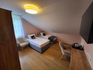 a small room with two beds and a tv at PannaiLew in Ciechocinek +13 photos