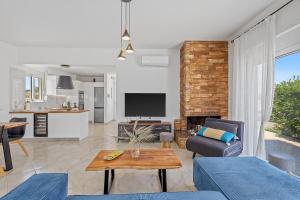 a living room with a couch and a table at S-EVA RESORT in Kolymbia