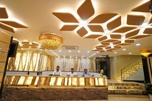 three men standing at a bar in a lobby at Hotel New Sundaram 150 Mtrs from Dargah in Ajmer