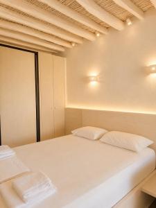 a bedroom with a white bed with two pillows at Cozy apartments Paros Kostos in Kóstos