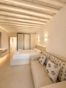 a bedroom with a bed and a couch at Cozy apartments Paros Kostos in Kóstos