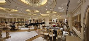 a dining room with tables and chairs and a chandelier at Casablanca Grand Hotel in Jeddah +68 photos