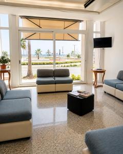 a living room with two couches and a tv at Hotel Alb's in Alba Adriatica