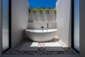 a bathroom with a bath tub in a room with rocks at Aqueduct resort in Ko Tao +56 photos