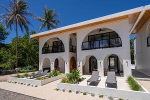 a house with chairs and palm trees at Aqueduct resort in Ko Tao