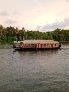 a boat with a roof on the water at Eleeza Homestay in Cochin