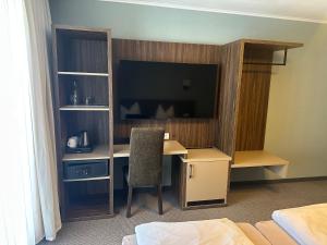 a room with a desk with a television and a chair at Hotel Restaurant Mirena in Marl