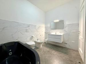 a bathroom with a toilet and a sink and a tub at Suite Home in Naples +38 photos