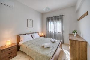 a bedroom with a bed with two towels on it at Viri Blue in Ágios Ioánnis