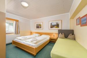 a bedroom with two beds and a green couch at Apparthotel Bliem in Schladming +114 photos
