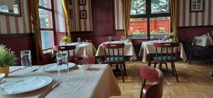 a dining room with tables and chairs and windows at Víghajós Panzió in Budapest