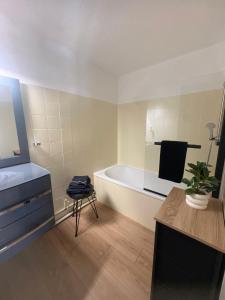 a bathroom with a tub and a sink and a chair at Le recantou duplex in Marseillan