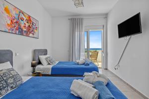 a bedroom with two beds and a flat screen tv at S-EVA RESORT in Kolymbia +43 photos