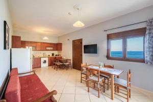 a kitchen and dining room with a table and a refrigerator at Viri Blue in Ágios Ioánnis
