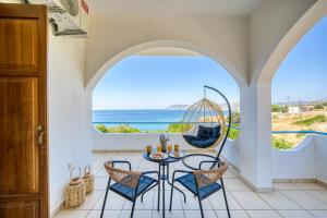 a room with a table and chairs and a view of the ocean at Viri Blue in Ágios Ioánnis