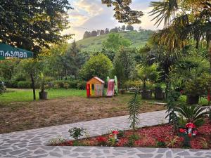 a garden with a play house and a playground at Guesthouse Kamelia in Martvili