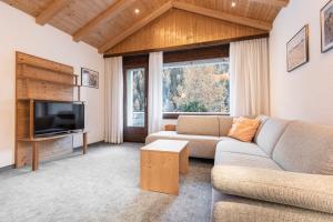 a living room with a couch and a tv at Atlantis Apartments by MEIN SAMNAUN - MOUNTAIN HOMES in Samnaun
