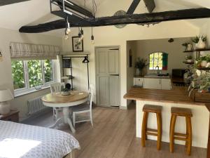 a kitchen and dining room with a table and a table and chairs at Lavender Lodge in Briston