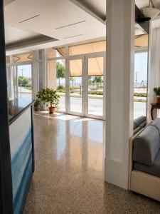 an office lobby with a large tv and a couch at Hotel Alb's in Alba Adriatica +42 photos