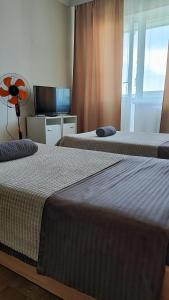 two beds in a hotel room with a fan at Водопійна 19 CityRooms in Bila Tserkva
