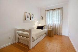 a white bedroom with a bed and a window at Beach House - Mountain And Ocean in Porto Formoso
