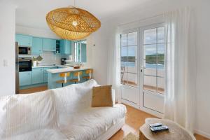 a living room with a white couch and a kitchen at Beach House - Mountain And Ocean in Porto Formoso