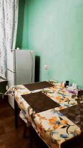 a kitchen with a table and a refrigerator at Водопійна 19 CityRooms in Bila Tserkva