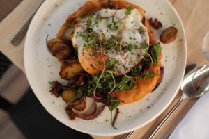 a plate of food with an egg and potatoes at Hotel Boss in Łódź