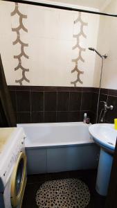 a bathroom with a white tub and a sink at Водопійна 19 CityRooms in Bila Tserkva +13 photos